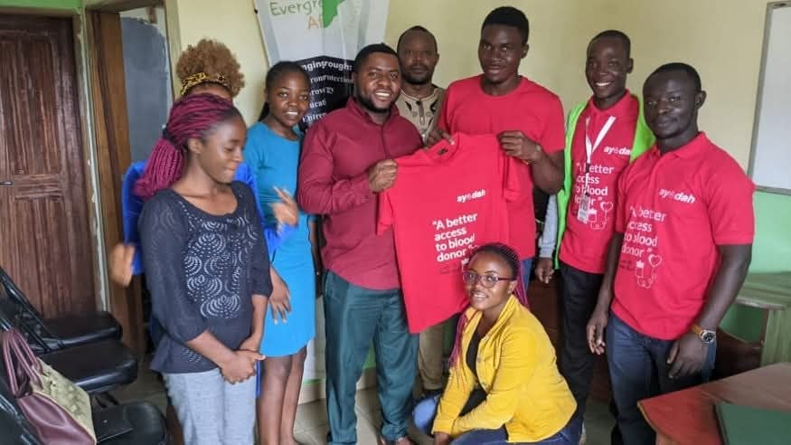 The Ayodah team and partners holding the campaign shirt reading ‘A better access to blood donor’.